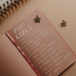 Top view of a 2021 goals notebook with handwritten list and star decorations, ideal for planning inspiration.